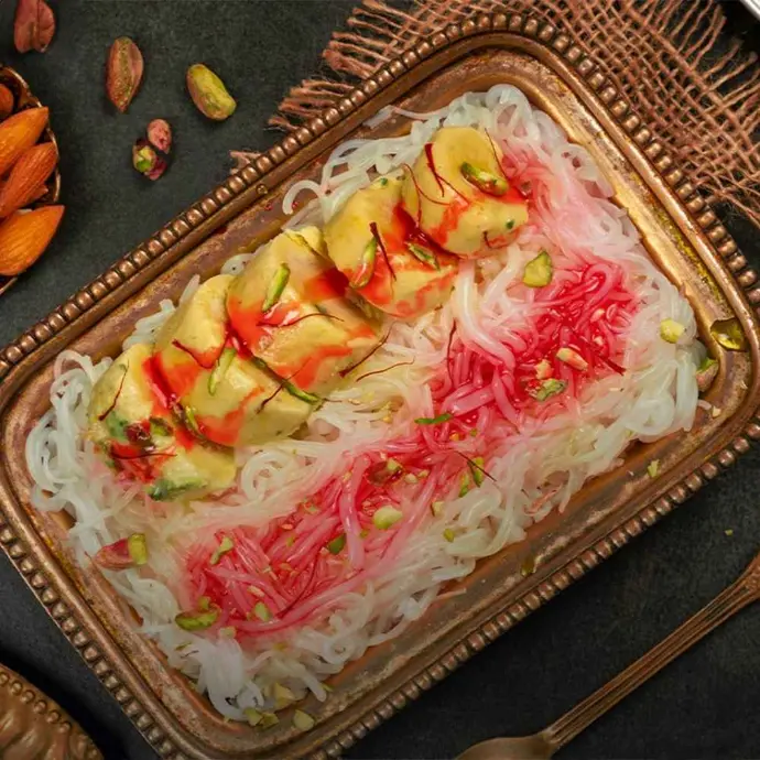 Creamy kulfi with falooda, rose syrup, basil seeds, and dry fruits